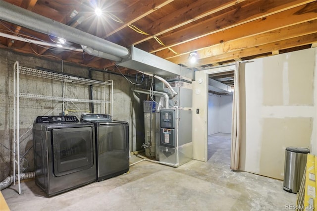 unfinished below grade area with heating unit and washer and clothes dryer