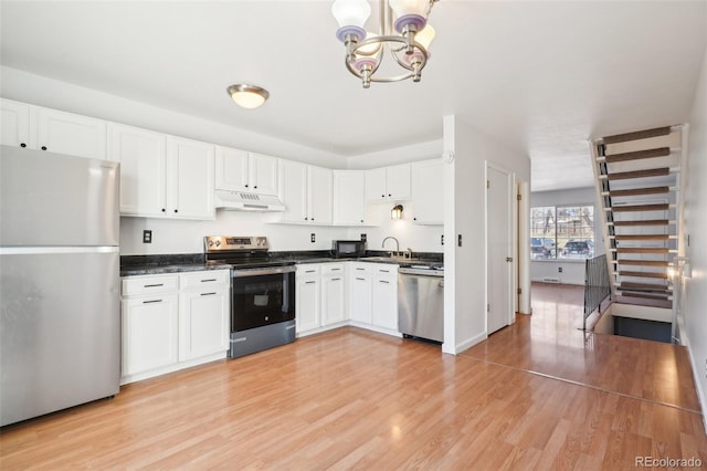 8975 Field St Unit 39, Broomfield, CO 80021 - kitchen featuring appliances with stainless steel finishes, under cabinet range hood, a chandelier, and white cabinetry