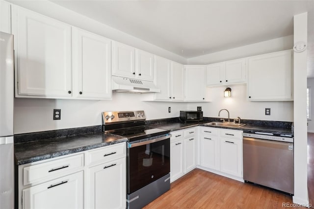 8975 Field St Unit 39, Broomfield, CO 80021 - kitchen featuring stainless steel appliances, under cabinet range hood, a sink, light wood-type flooring, and white cabinetry