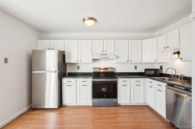 8975 Field St Unit 39, Broomfield, CO 80021 - kitchen featuring appliances with stainless steel finishes, under cabinet range hood, a sink, white cabinets, and dark countertops