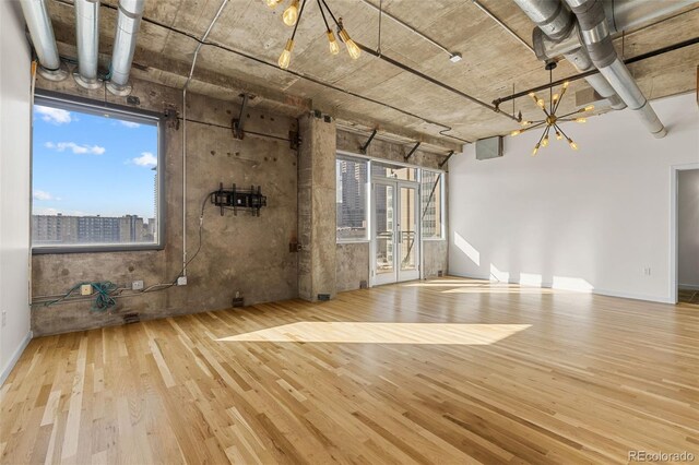 2020 Arapahoe St Unit 970, Denver, CO 80205 - unfurnished living room featuring wood finished floors, a chandelier, and baseboards