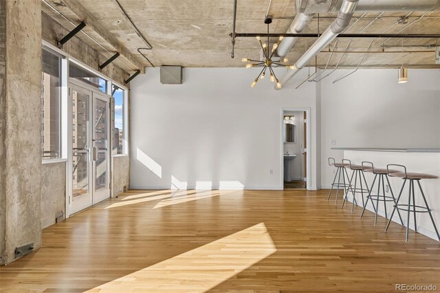 2020 Arapahoe St Unit 970, Denver, CO 80205 - empty room with wood finished floors, a chandelier, and baseboards