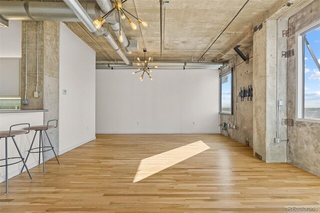 2020 Arapahoe St Unit 970, Denver, CO 80205 - spare room with a chandelier, wood finished floors, and healthy amount of natural light
