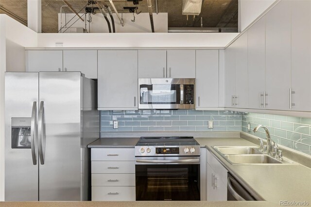 2020 Arapahoe St Unit 970, Denver, CO 80205 - kitchen with appliances with stainless steel finishes, a sink, tasteful backsplash, white cabinets, and light countertops