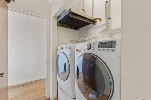 2020 Arapahoe St Unit 970, Denver, CO 80205 - laundry area featuring washer and dryer, light wood-style floors, and baseboards
