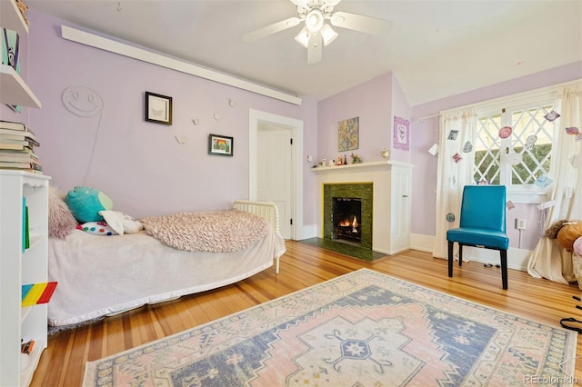 36 Lake Ave, Colorado Springs, CO 80906 - bedroom featuring wood finished floors, a lit fireplace, and a ceiling fan