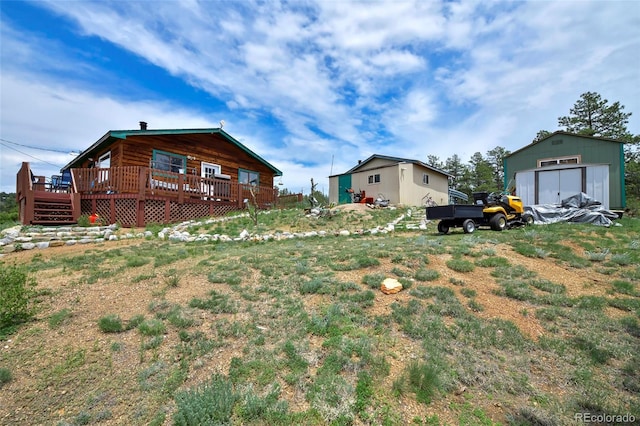 view of yard with a wooden deck and a storage shed