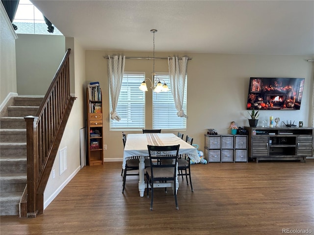 dining room with dark hardwood / wood-style floors and a chandelier