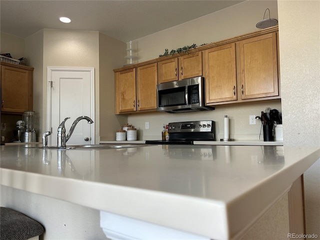 kitchen with sink, stainless steel appliances, and kitchen peninsula