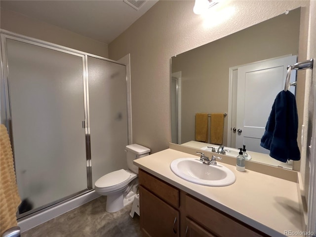 bathroom featuring vanity, a shower with door, and toilet