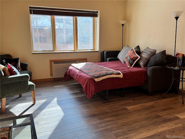 bedroom featuring hardwood / wood-style flooring and radiator