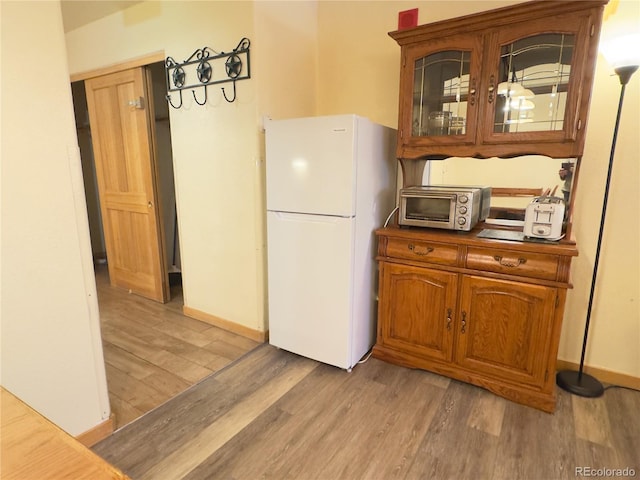 kitchen featuring wood-type flooring and white fridge