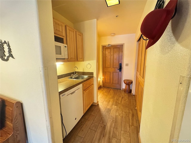 kitchen with white appliances, light brown cabinetry, light hardwood / wood-style flooring, and sink