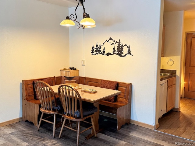 dining space with dark hardwood / wood-style flooring and a chandelier