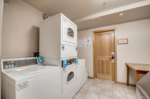 washroom featuring stacked washer and dryer, light tile patterned flooring, and independent washer and dryer