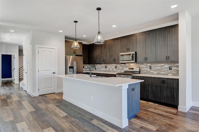 kitchen featuring an island with sink, stainless steel appliances, dark hardwood / wood-style floors, and sink