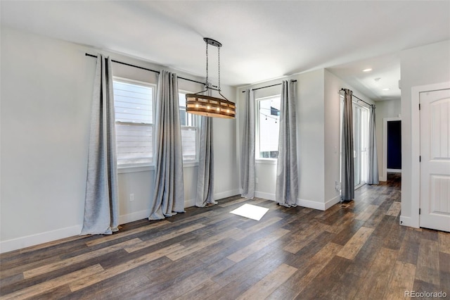 unfurnished dining area with dark wood-type flooring