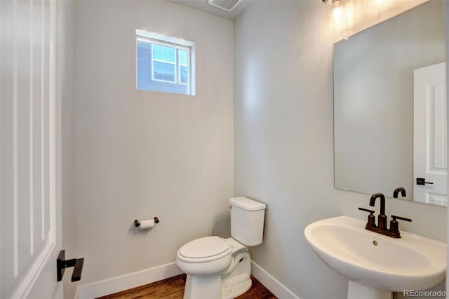 bathroom with toilet, sink, and hardwood / wood-style floors