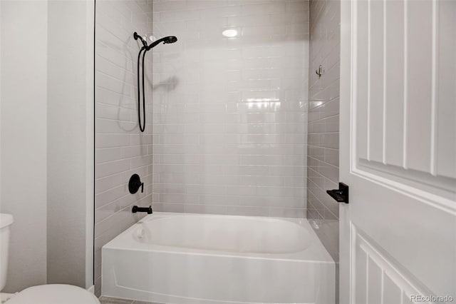 bathroom featuring tiled shower / bath and toilet