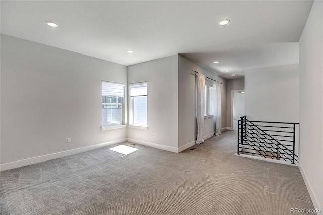 empty room featuring a wealth of natural light and light carpet