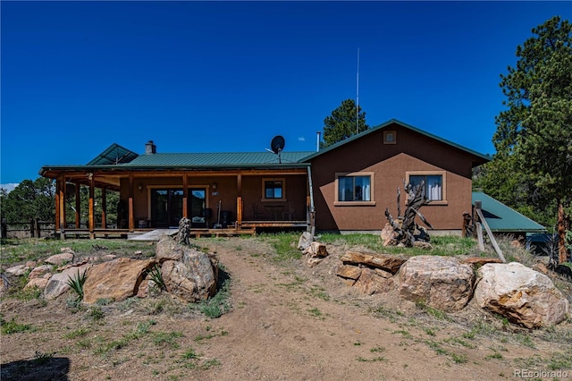 701/700 Bella Vista Ln, Cotopaxi, CO 81223 - rear view of property featuring a chimney, stucco siding, and metal roof
