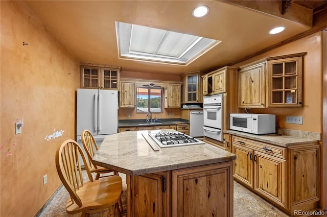701/700 Bella Vista Ln, Cotopaxi, CO 81223 - kitchen featuring white appliances, a sink, a warming drawer, a center island, and a kitchen breakfast bar