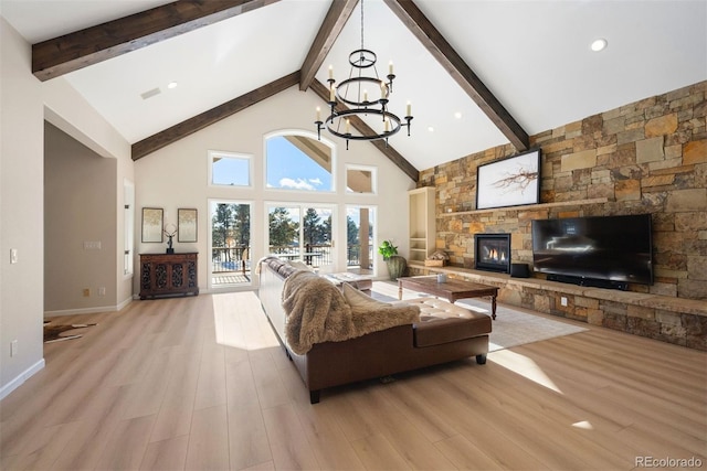 living room featuring beam ceiling, a fireplace, and light wood-type flooring