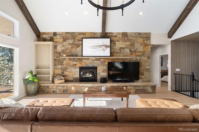 living room with beamed ceiling, light hardwood / wood-style floors, high vaulted ceiling, and a fireplace