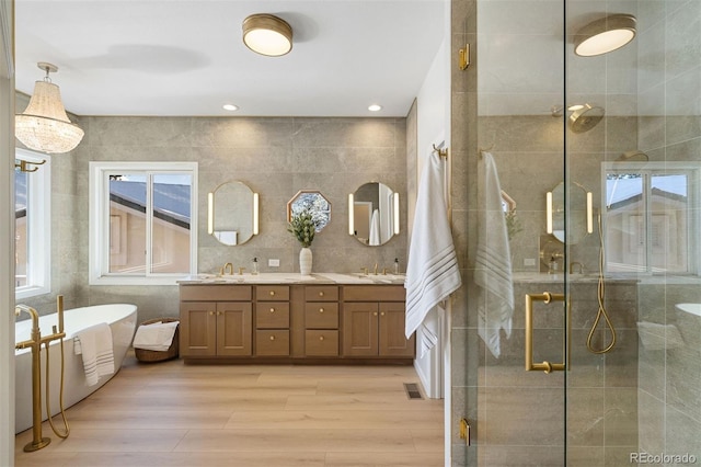 bathroom featuring decorative backsplash, hardwood / wood-style floors, vanity, and independent shower and bath