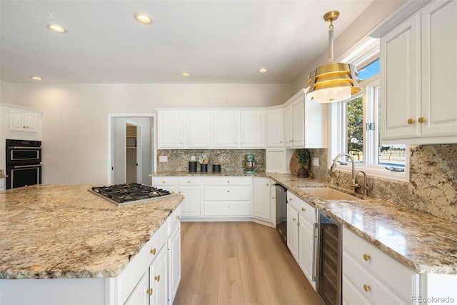 kitchen featuring stainless steel appliances, wine cooler, pendant lighting, white cabinets, and light wood-type flooring