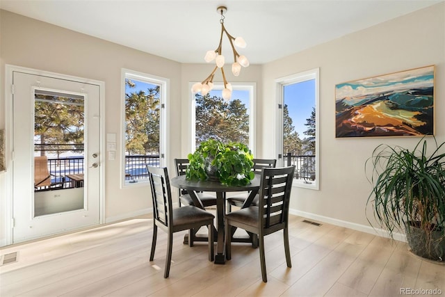 dining space featuring light hardwood / wood-style floors and a chandelier