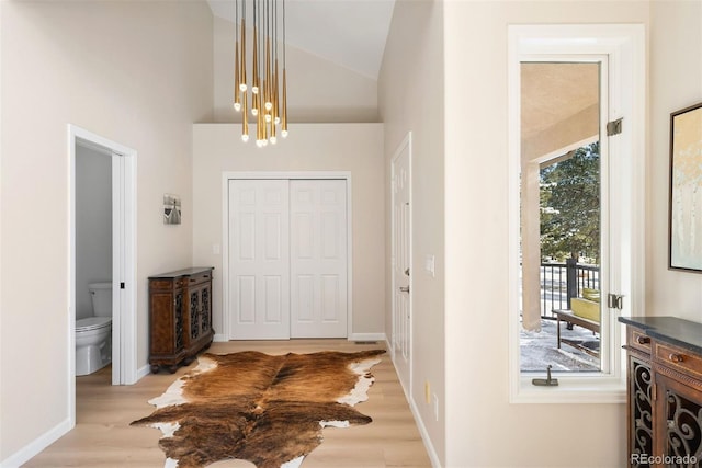 foyer entrance with plenty of natural light, light wood-type flooring, and an inviting chandelier