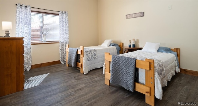 bedroom featuring baseboards and wood finished floors