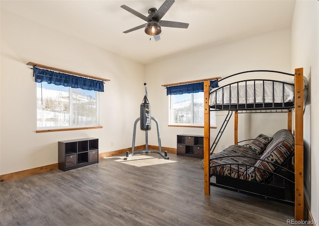 bedroom with ceiling fan, baseboards, and wood finished floors