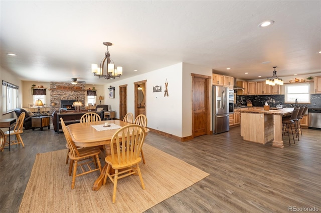 dining area with dark wood-style flooring, recessed lighting, a fireplace, and baseboards