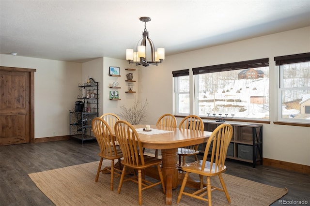 dining space with a notable chandelier, baseboards, and wood finished floors