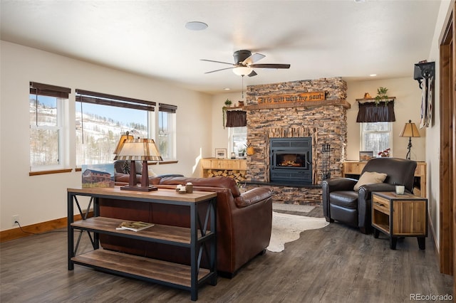 living room featuring baseboards, a ceiling fan, dark wood-style floors, a stone fireplace, and recessed lighting