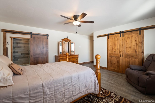 bedroom with a barn door, baseboards, ceiling fan, and wood finished floors