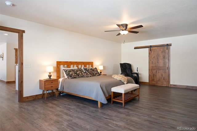 bedroom with a ceiling fan, wood finished floors, baseboards, and a barn door