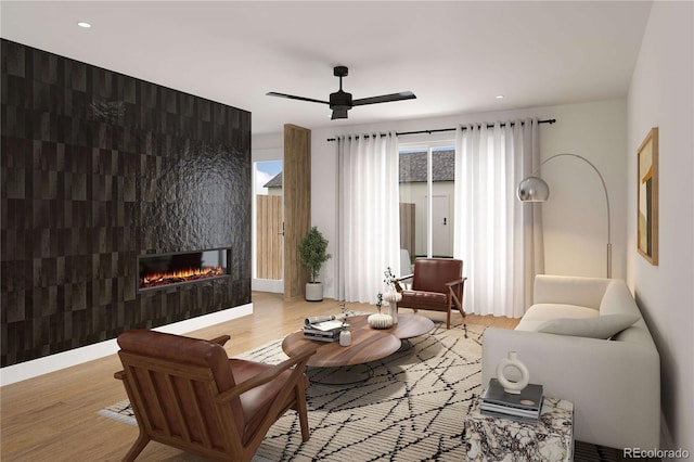 living room with an accent wall, ceiling fan, recessed lighting, a tile fireplace, and wood finished floors