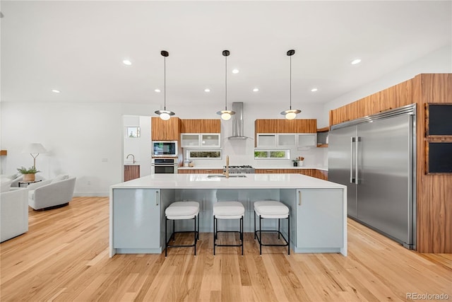 1490 S Vine St, Denver, CO 80210 - kitchen with built in appliances, light countertops, wall chimney exhaust hood, a spacious island, and modern cabinets