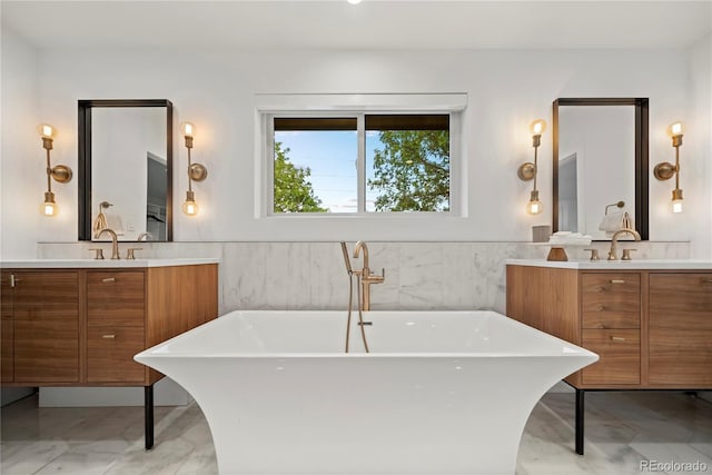 1490 S Vine St, Denver, CO 80210 - bathroom with marble look tile flooring, two vanities, a soaking tub, a wainscoted wall, and tile walls