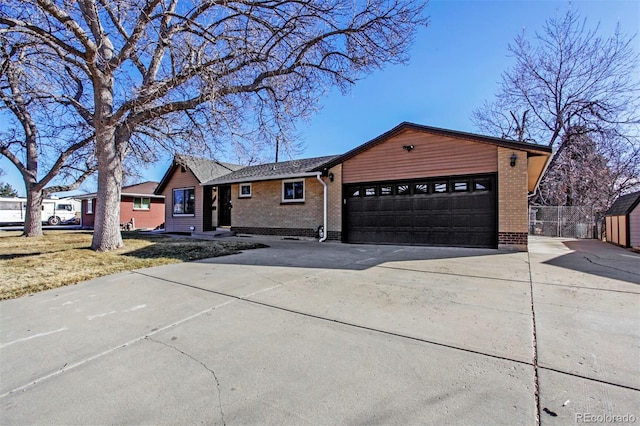 ranch-style house with driveway, a garage, fence, and brick siding