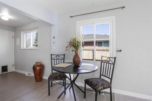 dining area featuring visible vents, baseboards, and wood finished floors