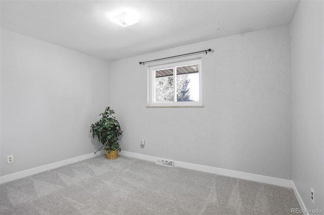 empty room featuring baseboards, visible vents, and carpet flooring