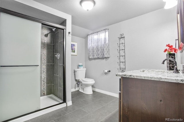 bathroom with toilet, a shower stall, vanity, baseboards, and tile patterned floors