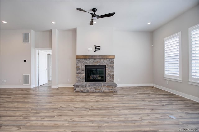 unfurnished living room with a fireplace, light hardwood / wood-style floors, and ceiling fan