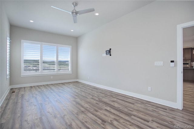 empty room with ceiling fan and light wood-type flooring