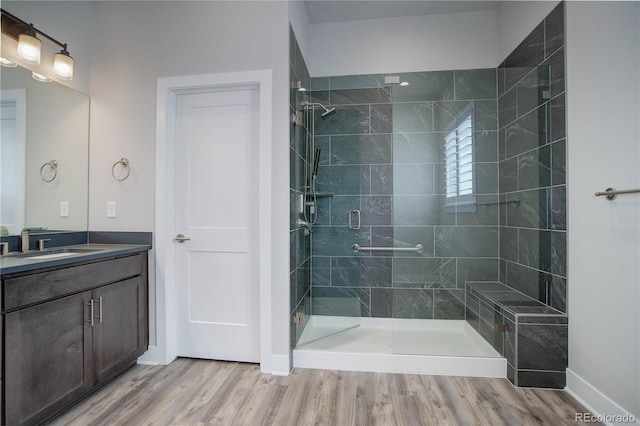 bathroom featuring walk in shower, vanity, and hardwood / wood-style flooring