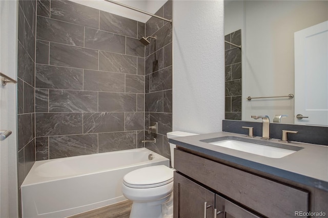 full bathroom with toilet, vanity, tiled shower / bath, and hardwood / wood-style floors